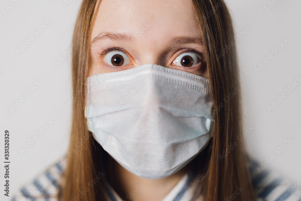 girl puts on a medical mask on a white background. corona virus prevention.corona virus prevention.scientist in biological protective Epidemic virus outbreak concept. COVID-19 girl puts on a medical mask on a white background. corona virus prevention.corona virus prevention.scientist in biological protective Epidemic virus outbreak concept. COVID-19