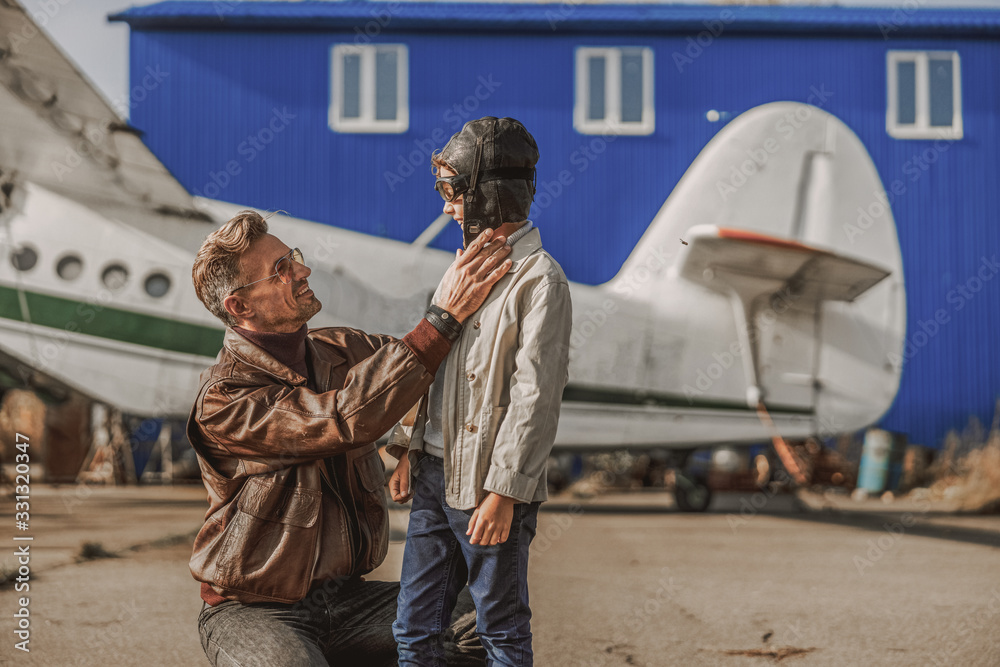 Happy man and his kid looking each other near plane