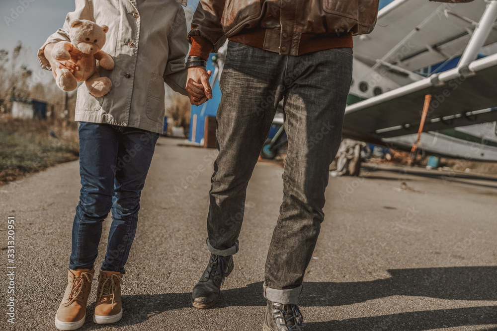 Father and son walking together near plane Father and son walking together near plane