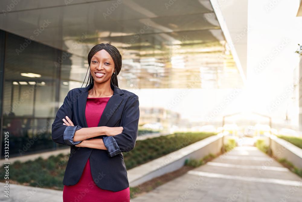 Smiling African American businesswoman standing outside of an office building Smiling African American businesswoman standing outside of an office building