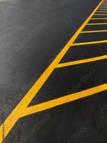 black asphalt with yellow no parking stripes