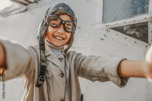 Smiling cute child in aviator glasses making photo outdoors
