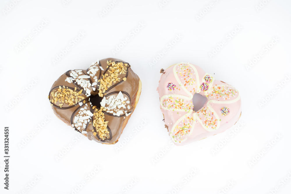 Heart shaped donuts isolated on white background. Tasty unhealty dessert items. A set of two Heart shaped donuts isolated on white background. Tasty unhealty dessert items. A set of two