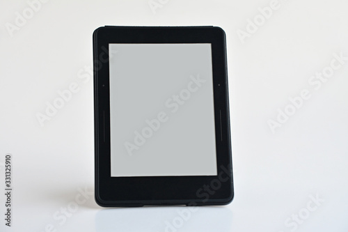 Digital e-book reader stand on the white background.Blank screen is ready for any text message.Close up taken.
