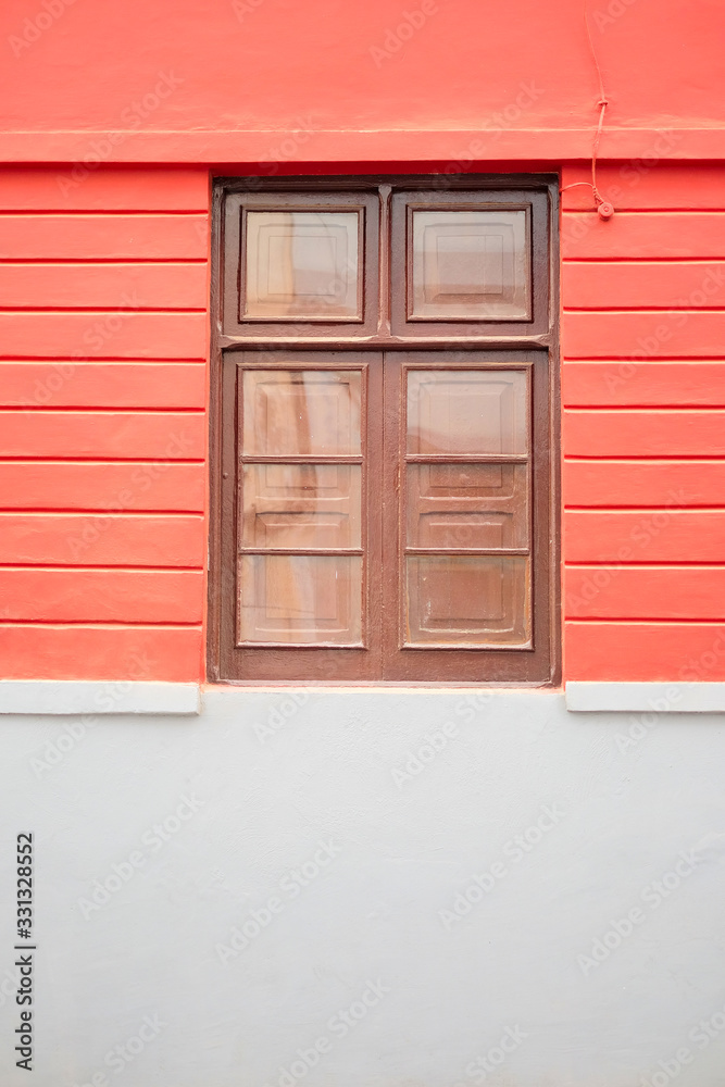 Simple brown wooden window in a coral pink wall. Simple brown wooden window in a coral pink wall.