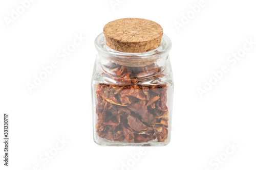 dried tomatoes in a glass jar isolated on white background. spices and food ingredients