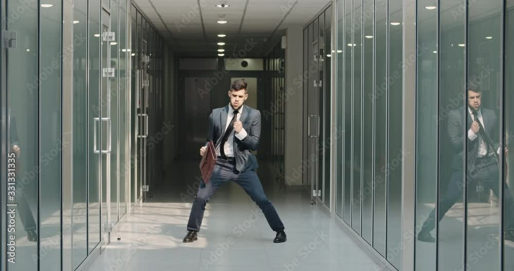 Funny businessman making dance break in office hall, celebrating his ...