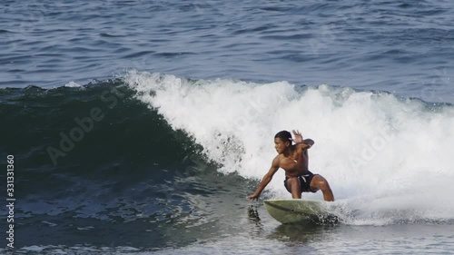 Close up slow motion shot of Handsome guy surfing a green wave in Indonesia, Java