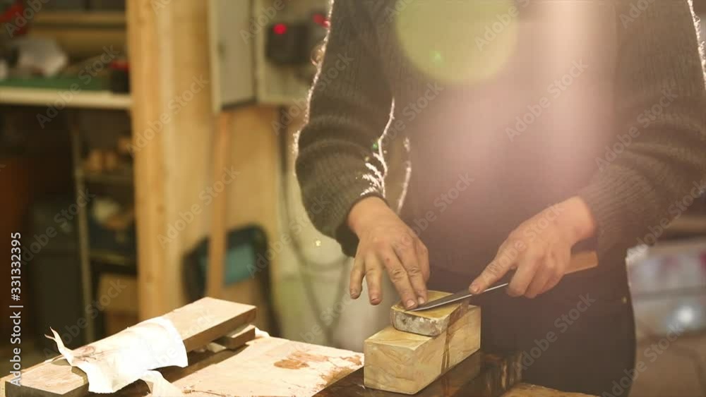 Bladesmith grinding a knife on grindstone