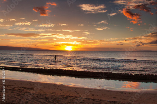 View of a standup paddler at sunset on Maui.