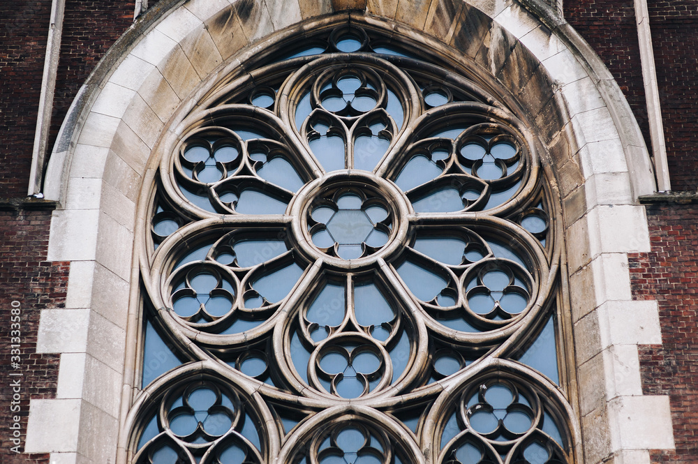 Round window with stained glass on facade of the building. Baroque and Gothic architecture. Church of St. Olga and Elizabeth. Lviv, Ukraine.
