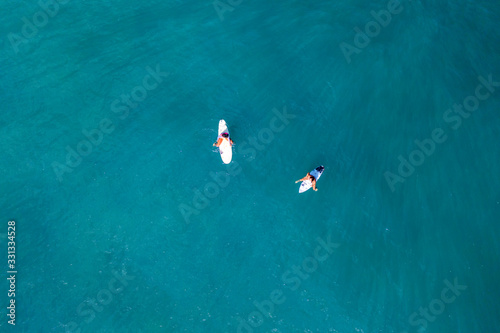 Two surfers in the ocean waiting a wave. shot from above 