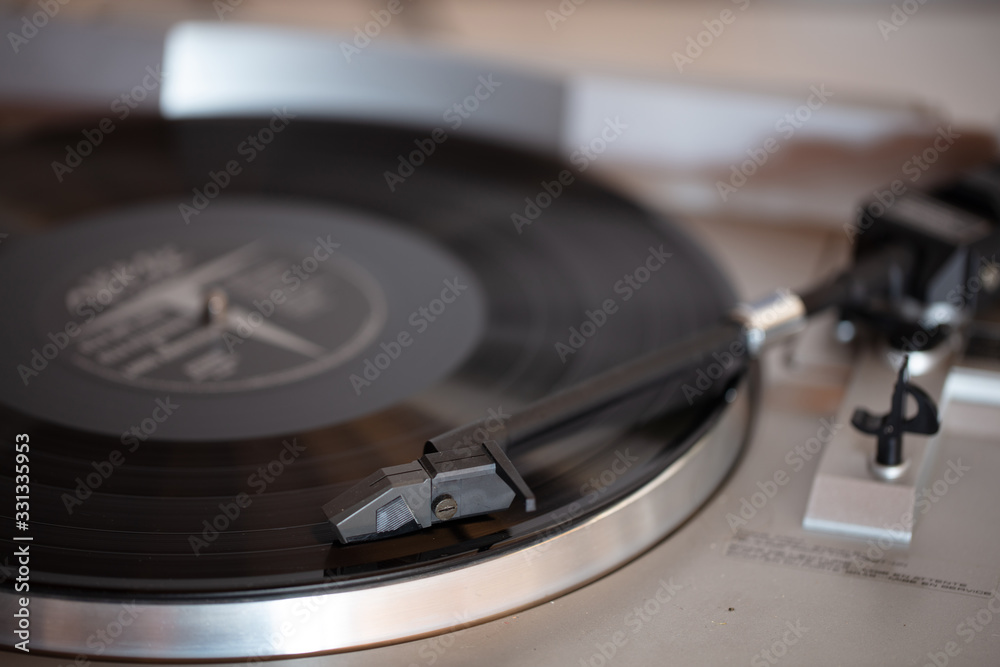 Close up of turntable needle on a vinyl record. Turntable playing vinyl. Needle on rotating black vinyl.