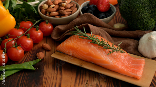Cropped shot of ingredients for healthy food with salmon, fruits, vegetable and seeds on rustic table
