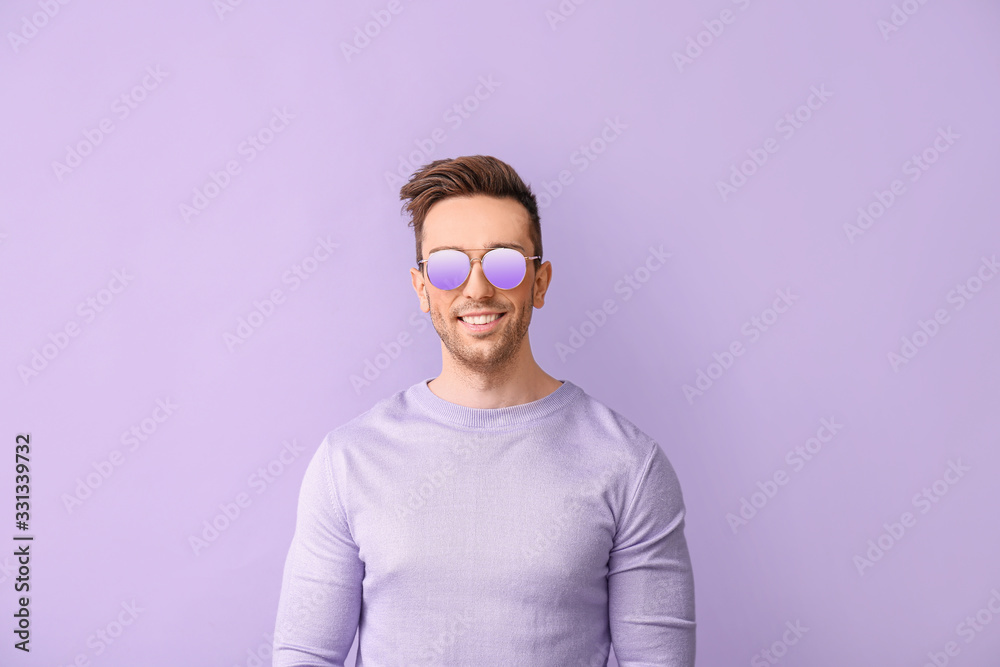 Young man with stylish sunglasses on color background Young man with stylish sunglasses on color background