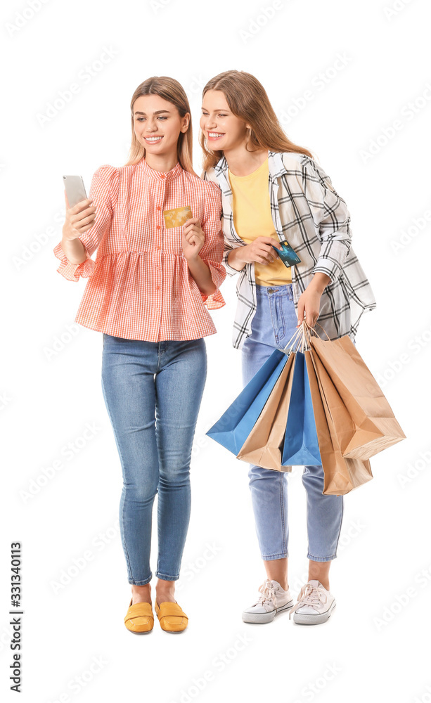 Young women with shopping bags and mobile phone on white background Young women with shopping bags and mobile phone on white background