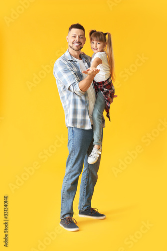 Father and his little daughter dancing against color background © Pixel-Shot