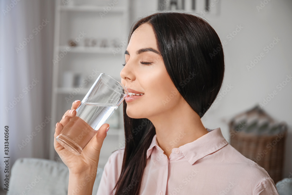 Beautiful young woman drinking water at home Beautiful young woman drinking water at home