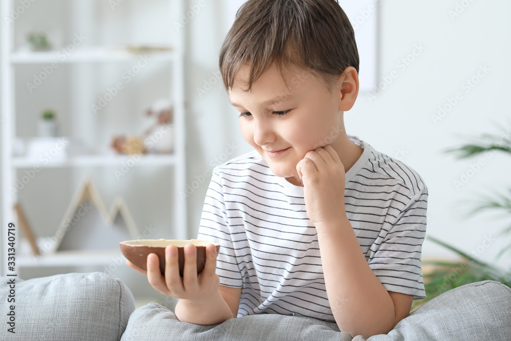Cute little boy with sweet chocolate egg at home Cute little boy with sweet chocolate egg at home