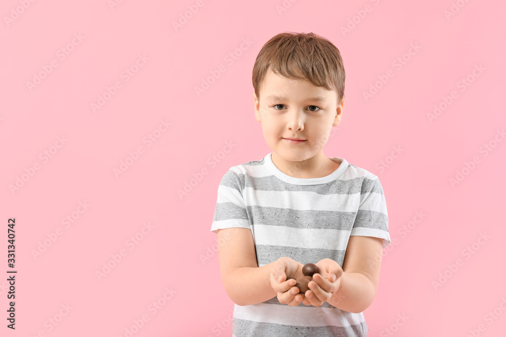Cute little boy with sweet chocolate eggs on color background Cute little boy with sweet chocolate eggs on color background