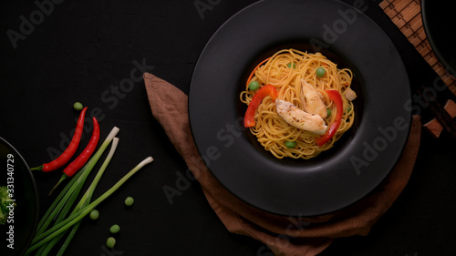 Top view of Schezwan Noodles with vegetable and chicken in black plate