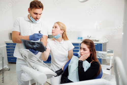 The dentist makes the examination. the Intern observes