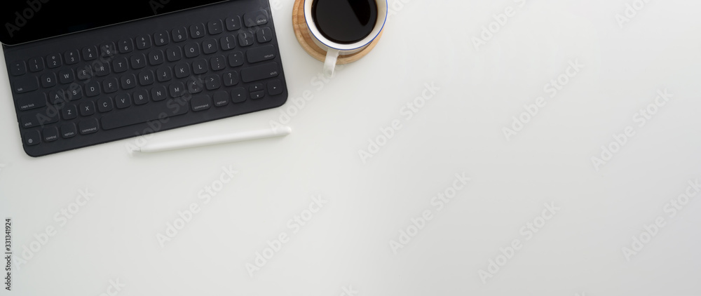 Top view of simple workspace with digital tablet, stylus, coffee cup