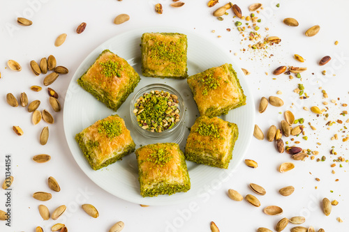 Traditional Turkish Pastry Dessert Baklava designed in round plate with pistachio nuts,with copy space.