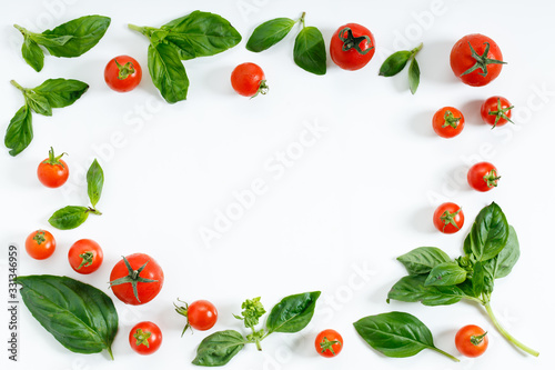 red cherry tomato and basil leaf on white background