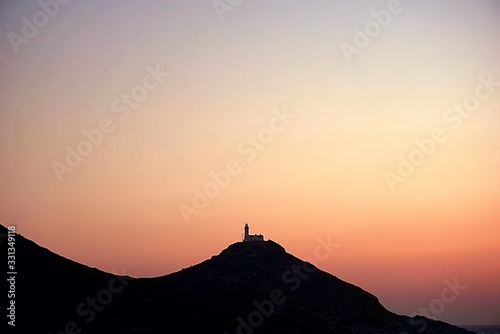 sunset over the mountains and a lighthouse