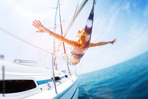 Young woman enjoys tropical sailing in the hammock set on the yacht. Tilt shift effect applied