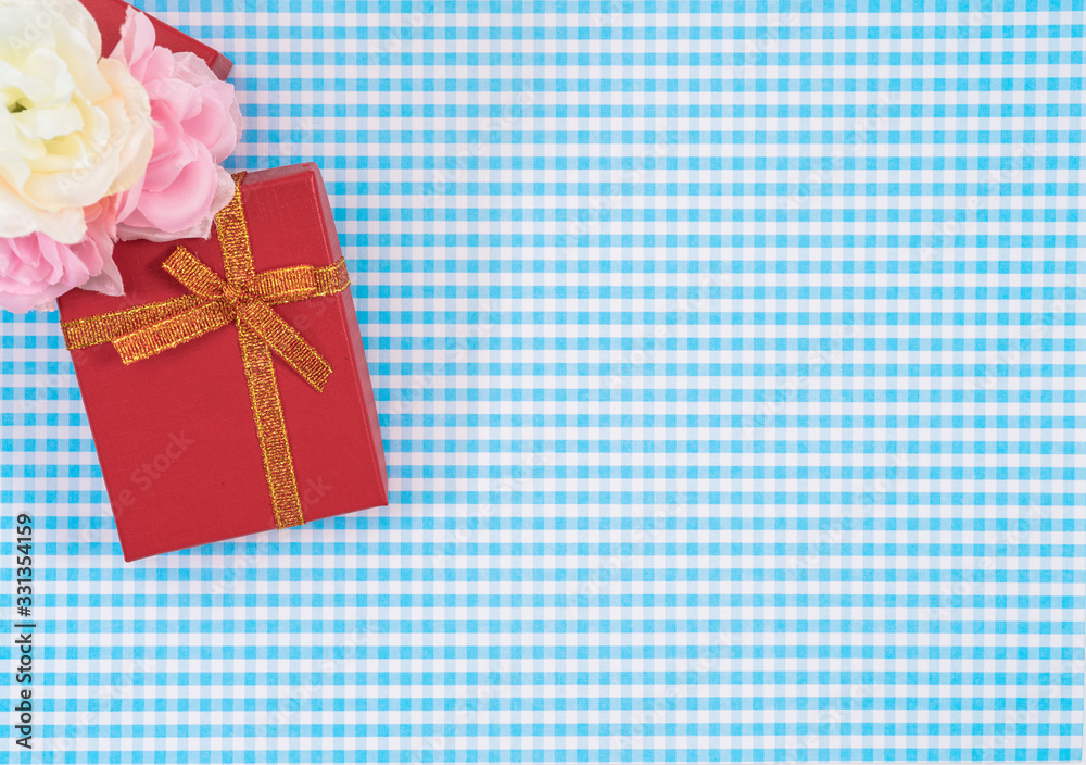 gift box with red isolated on Plaid background. Holiday decoration for Mother's Day or Women's Day. gift box with red isolated on Plaid background. Holiday decoration for Mother's Day or Women's Day.