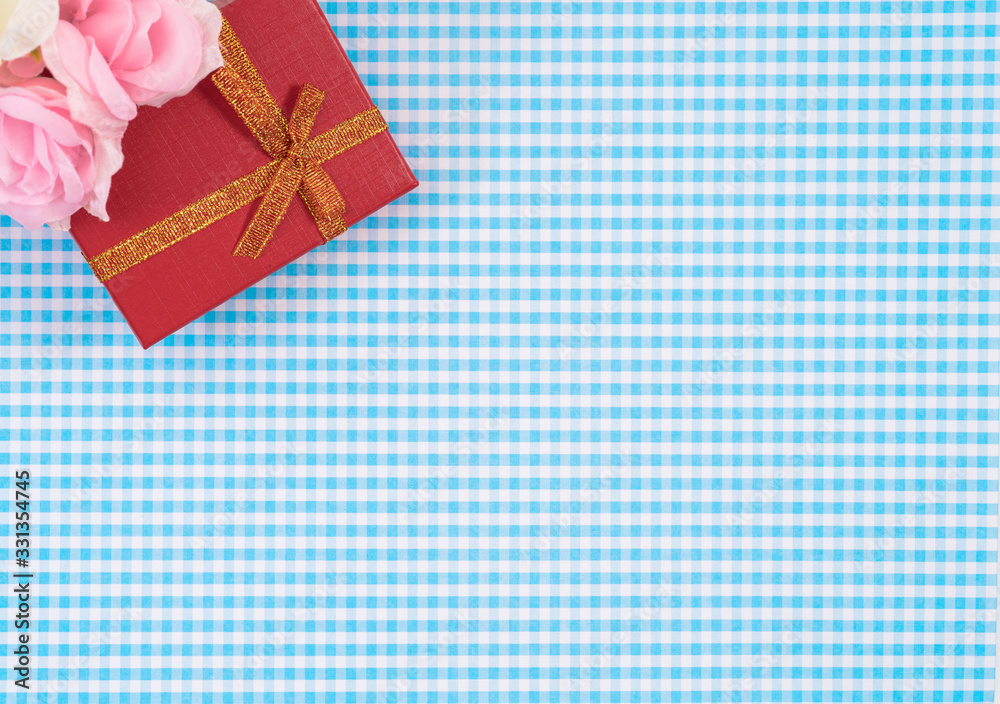 gift box with red isolated on Plaid background. Holiday decoration for Mother's Day or Women's Day. gift box with red isolated on Plaid background. Holiday decoration for Mother's Day or Women's Day.