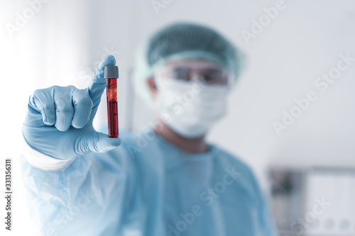 Photos The blood sample in test tube holding by technician in the medial laboratory to analysis for viral infection in the patient, concept of medical science and technology role in epidemic of covid 19