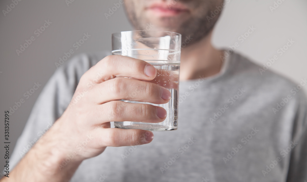 Caucasian man holding glass of water. Caucasian man holding glass of water.
