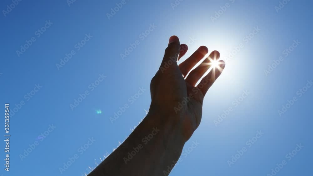 Silhouette hand of man reach to sun and deep blue sky. Conceptual scene Silhouette hand of man reach to sun and deep blue sky. Conceptual scene