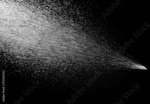 Water spray stream on black background photo