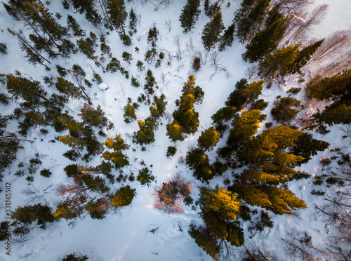 Aerial view fly over of a winter snow-covered forest. Winter forest texture. Aerial view. Aerial drone view of a winter landscape. Snow covered forest photo