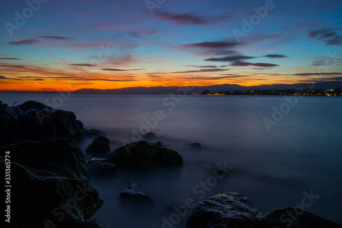 Beautiful evening photo of Lac Leman close to Lausanne, with sun just behind the horizon and long exposure of water.