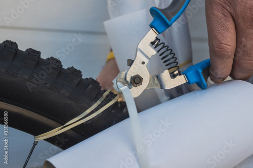 Cutting the zip ties from a factory packed new bicycle, taken out of a cardboard box. Cutting the ties around rubber tires. photo