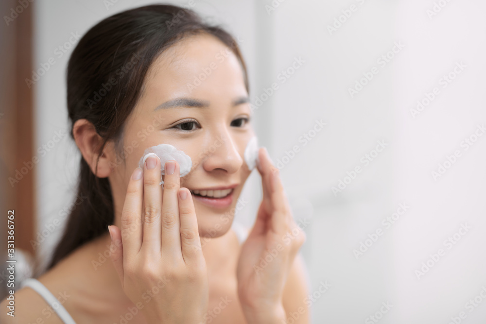 Happy beautiful lady cleaning her face with soap in bathroom Happy beautiful lady cleaning her face with soap in bathroom