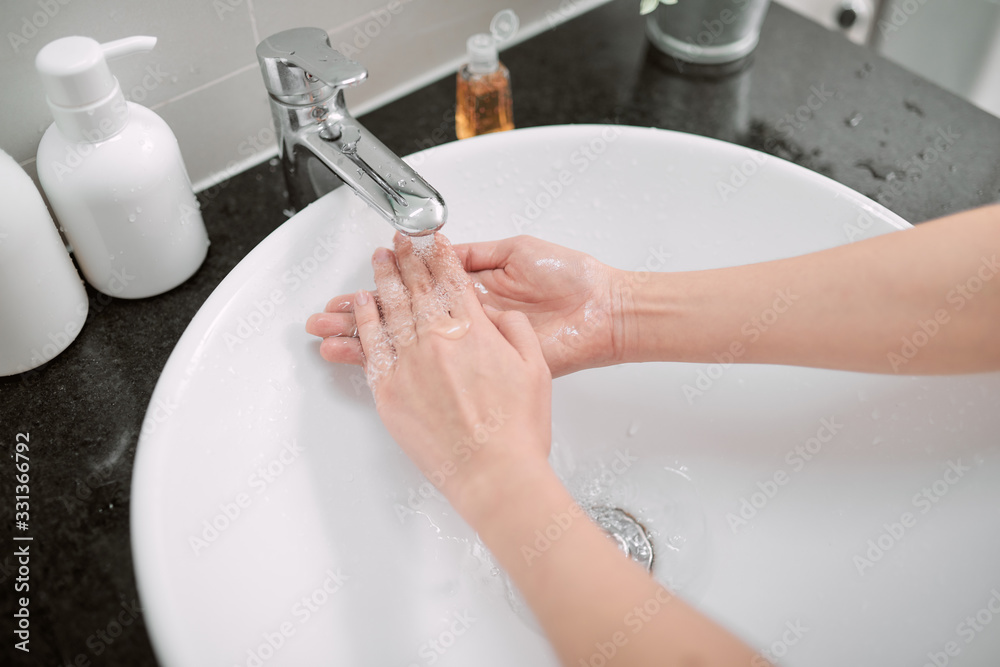 Washing hands with soap in bathroom, closeup Washing hands with soap in bathroom, closeup