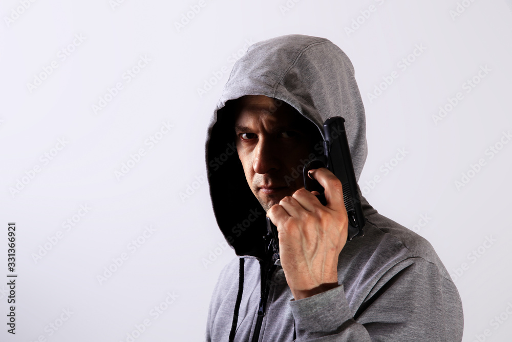 Evil man holds gun in hand and hood on head, major plan Evil man holds gun in hand and hood on head, major plan