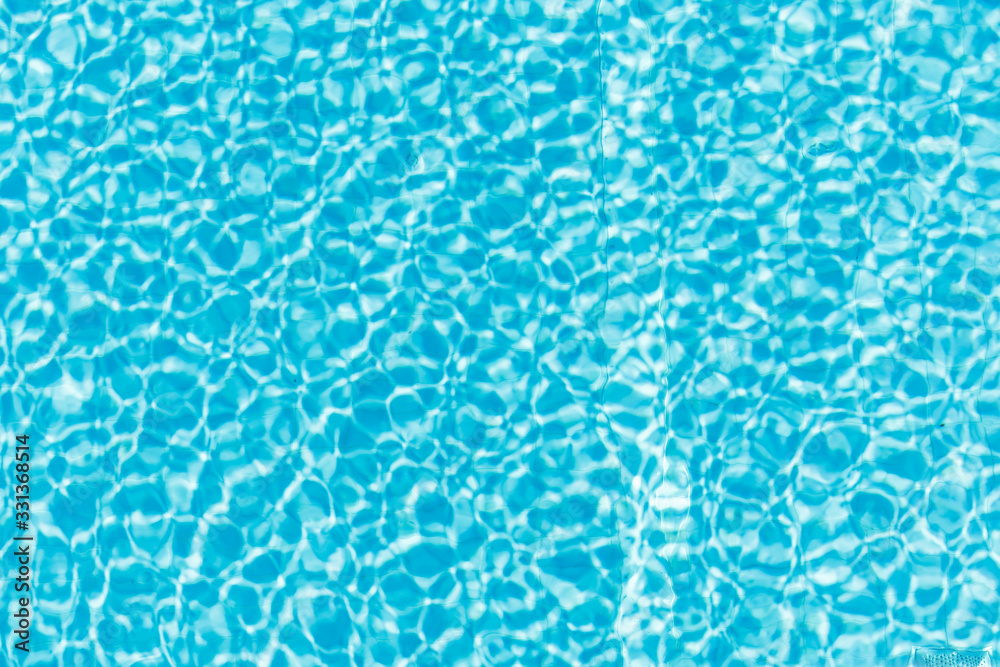 Surface of blue shining swimming pool water ripple and sun reflection. Perfect as a background for summer, vacation, calmness, serenity or any other idea. Surface of blue shining swimming pool water ripple and sun reflection. Perfect as a background for summer, vacation, calmness, serenity or any other idea.