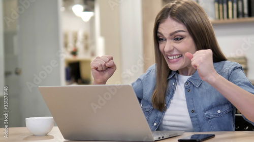 Creative Woman Celebrating Success while Working on Laptop