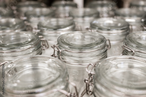 A group of empty cans with a lid. Rows of glass containers in a store. Close-up.