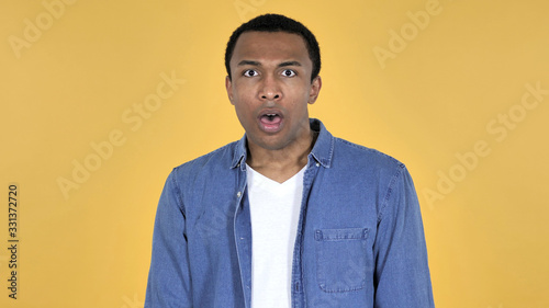 Surprised Young African Man in Shock Isolated on Yellow Background, wondering