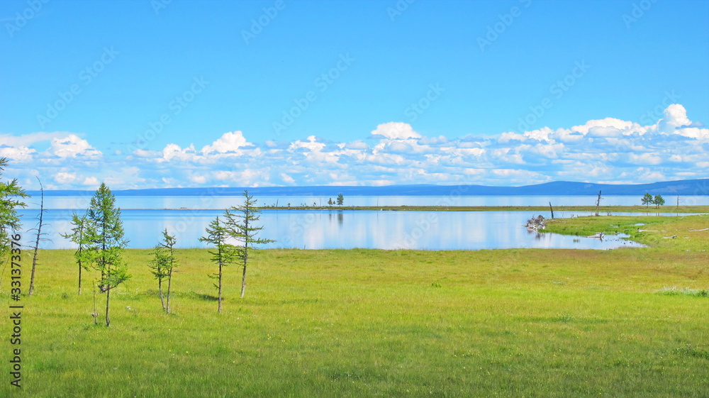 Lake Baikal. The steppe coast of Olkhon island with cozy sandy bays, rare larches and green meadows. Beautiful summer landscape Lake Baikal. The steppe coast of Olkhon island with cozy sandy bays, rare larches and green meadows. Beautiful summer landscape