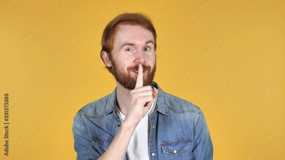 Redhead Man Gesturing Silence, Finger on Lips, Yellow Background Redhead Man Gesturing Silence, Finger on Lips, Yellow Background