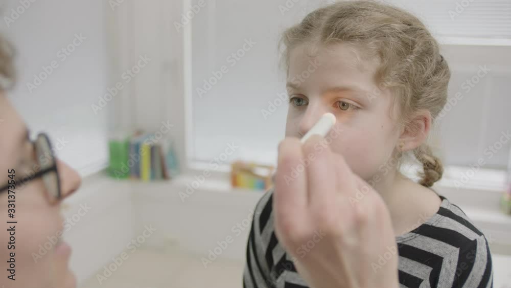 Girl Being Tested For Coronavirus By Doctor Checking Eyes, Mouth And Shoulders